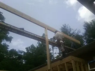Carpenter setting a ridge beam over a new addition frame — Ice Dam Removal by Roofing Brothers in San Carlos