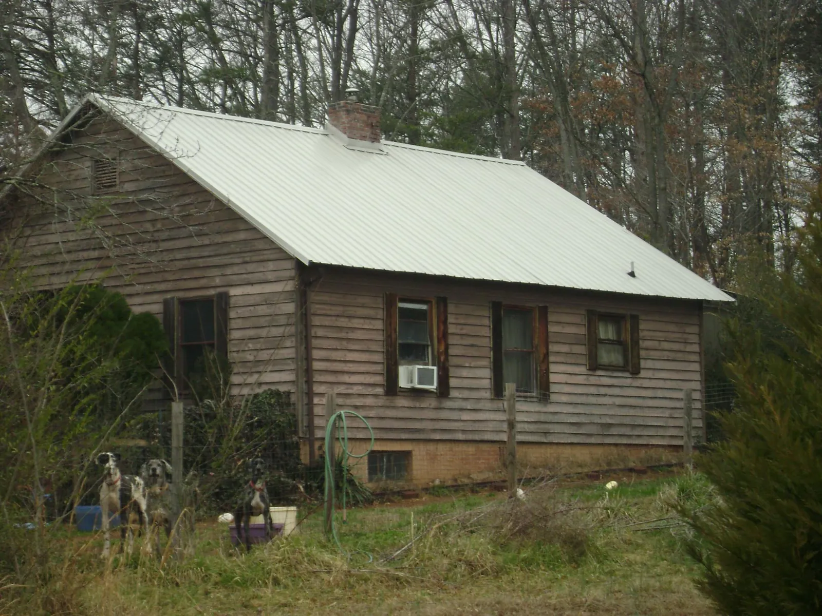 White metal roof on an old wood sided farmhouse, from a Metal Roof Installation job in San Carlos
